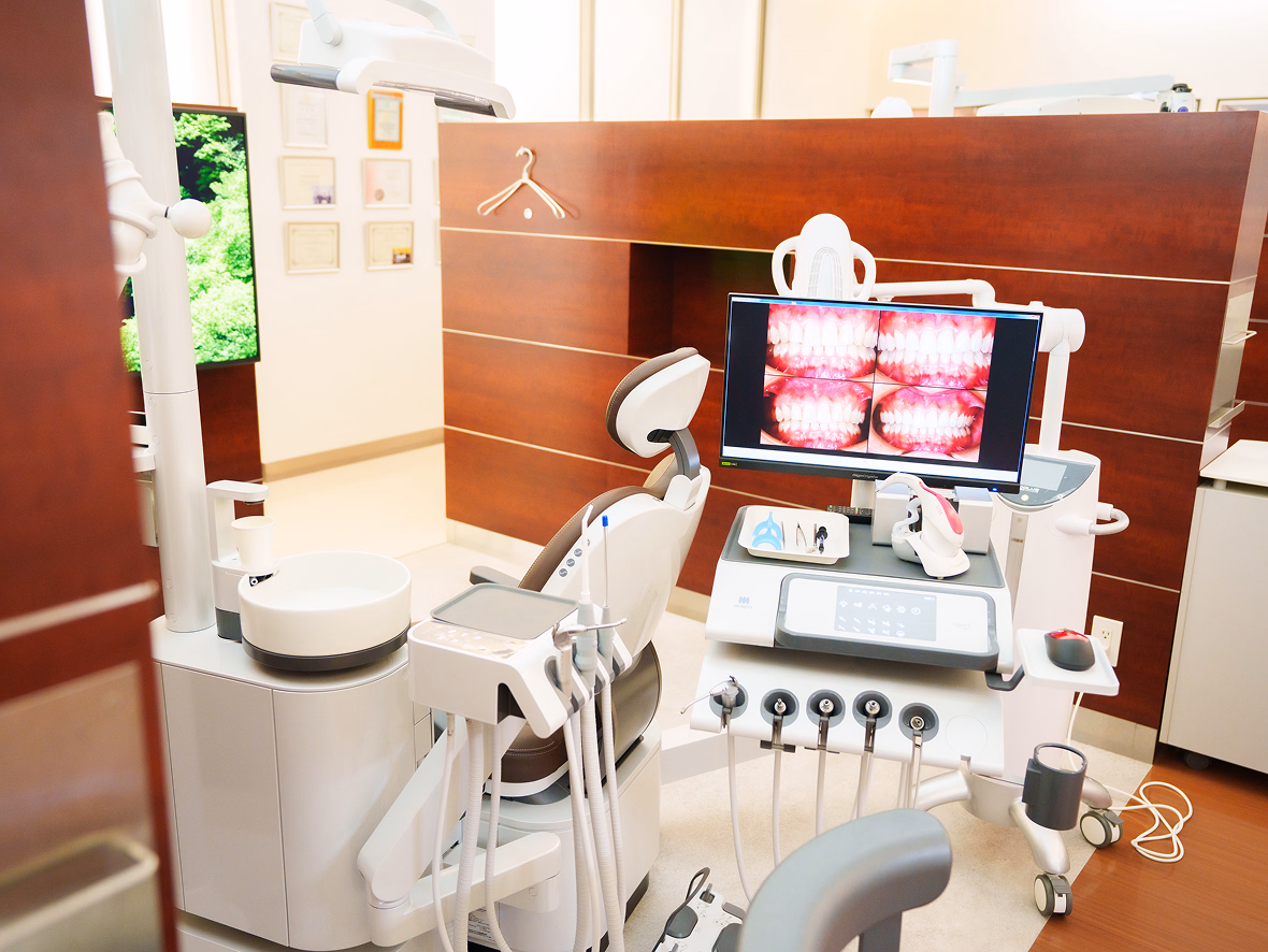 歯科ユニットと口腔内写真が映るモニターを備えた治療スペース