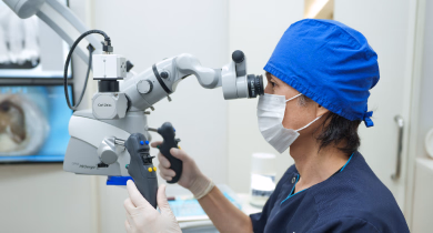 歯科用マイクロスコープを使って精密検査を行う歯科医師