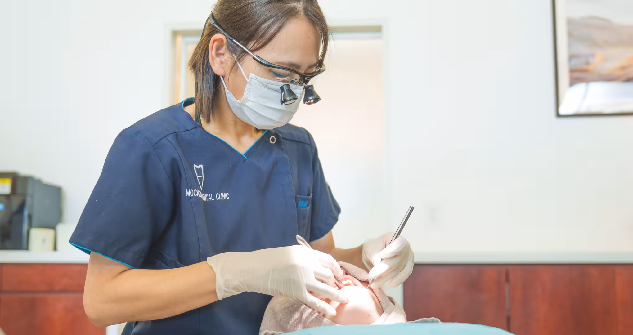 歯科医師がルーペを装着して患者の口腔内を診察している様子